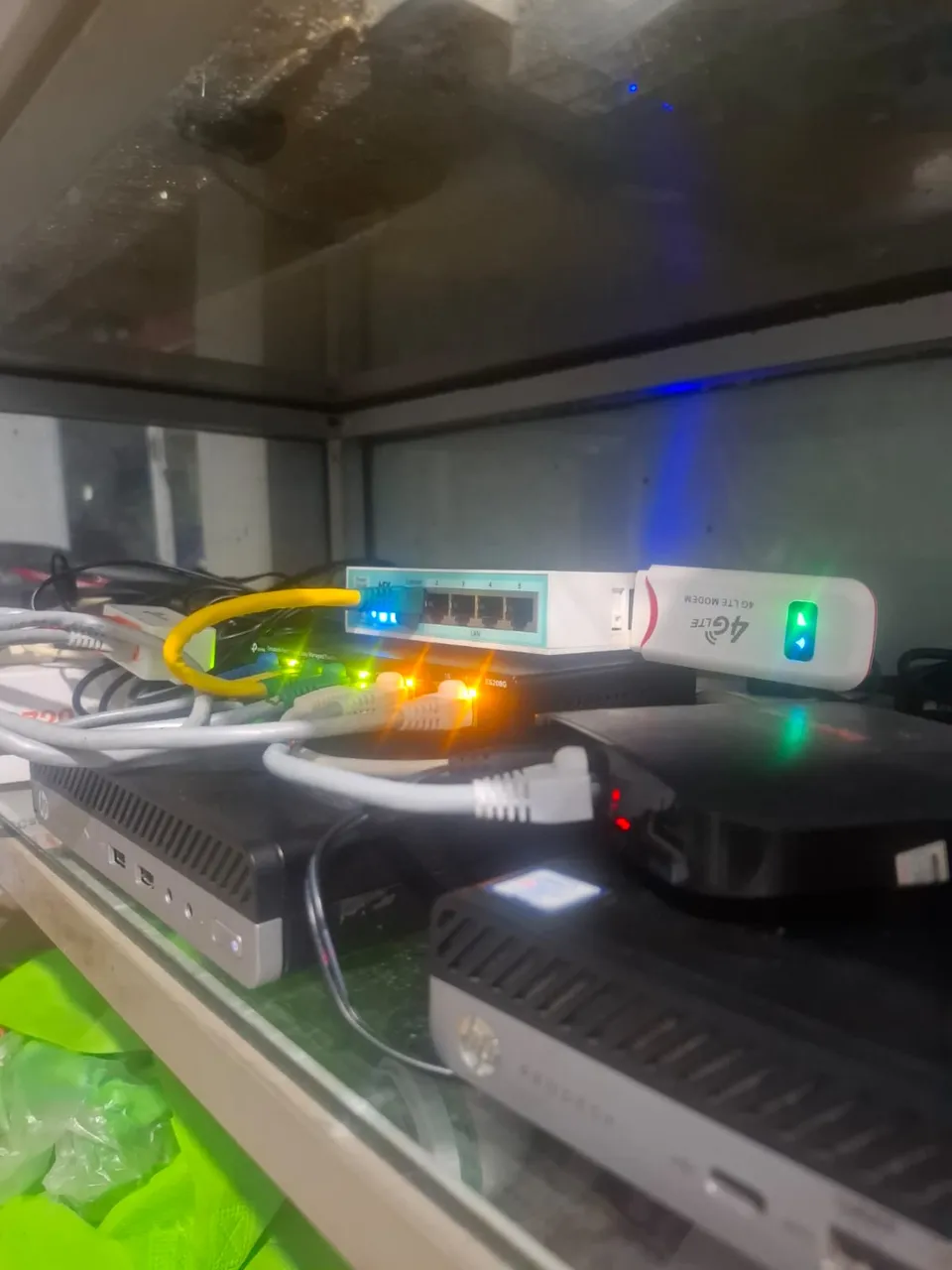 Physical home server hardware setup with mini PC, network switch, and 4G modem